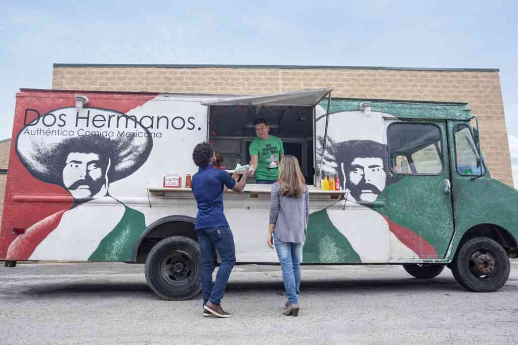 Dos Hermanos Taco Truck employee and two customers