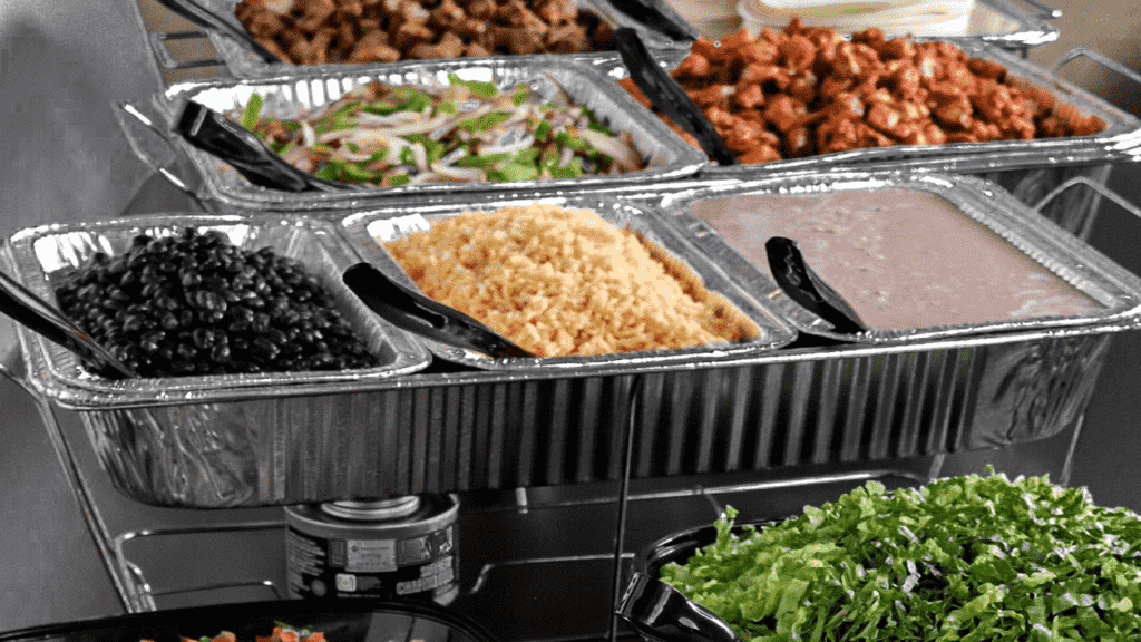 Rice, chicken, and assortment of ingredients for catering event spread